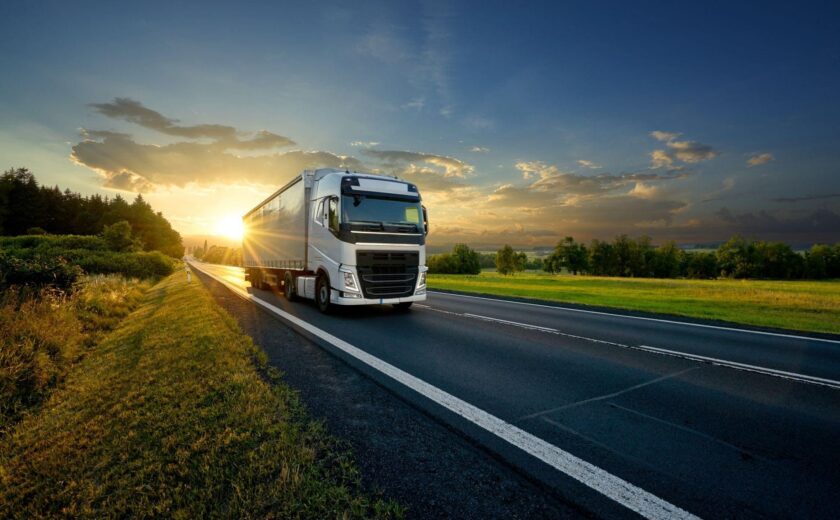 HGV driving along road at sunset