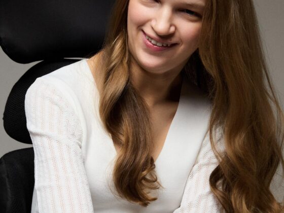 Holly seated in wheelchair smiling