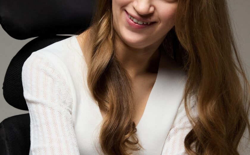 Holly seated in wheelchair smiling