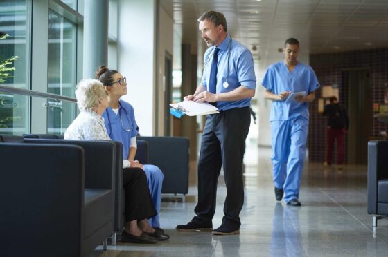 Hospital staff discussing patient care in corridor