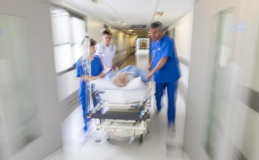 Hospital team moving patient through corridor