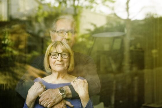 Husband and wife looking through window