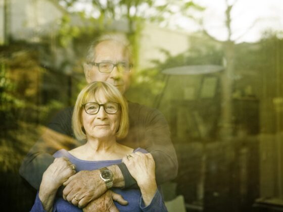 Husband and wife looking through window