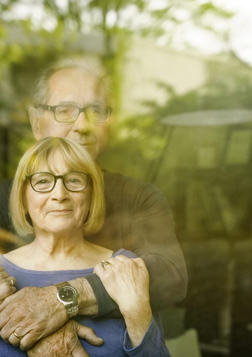 Husband and wife looking through window