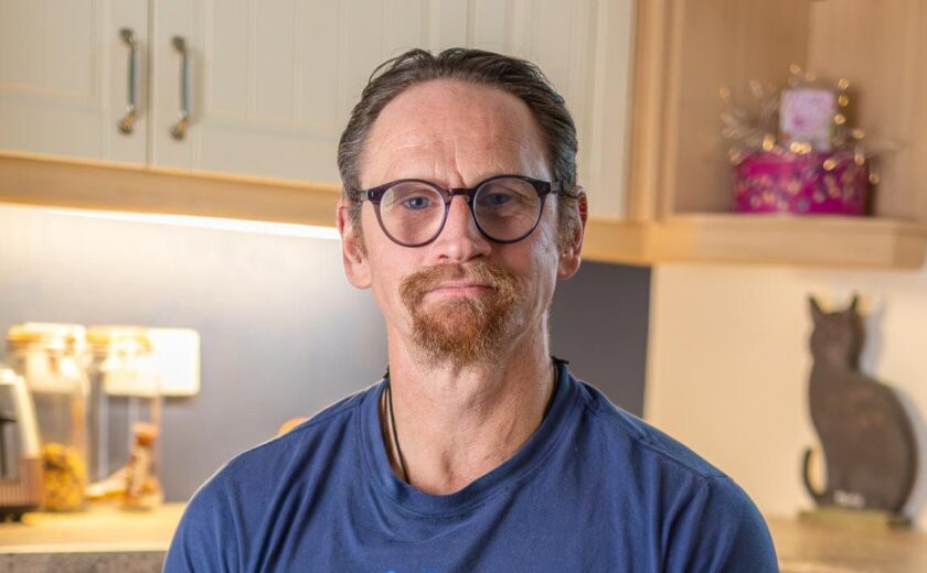 Ian Westmoreland with glasses seated in kitchen