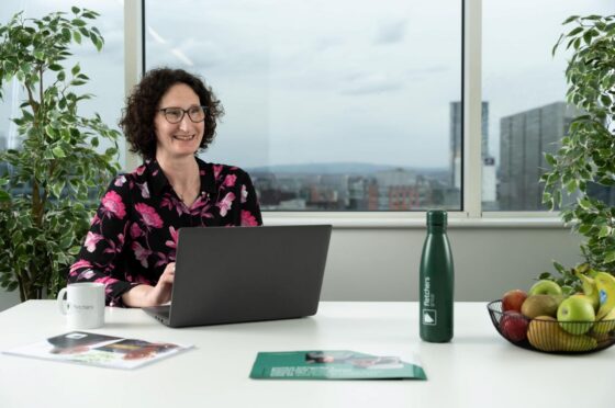 Mary Lomas seated at desk with laptop