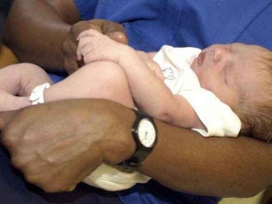 Midwife caring for newborn baby in hospital