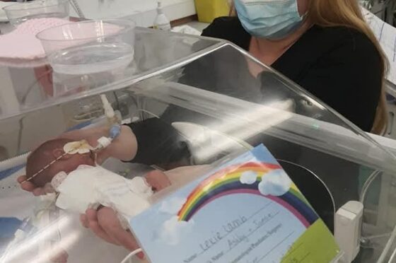 Mother visiting newborn baby in incubator