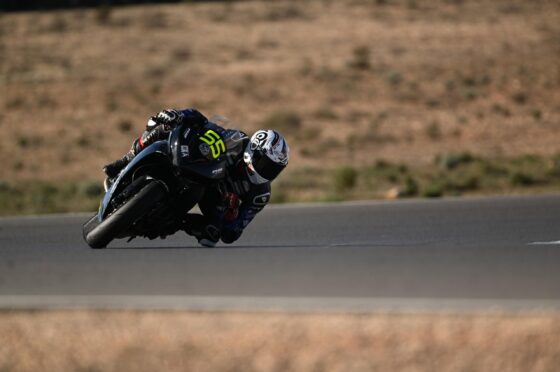 Motorcycle racer leaning into track bend