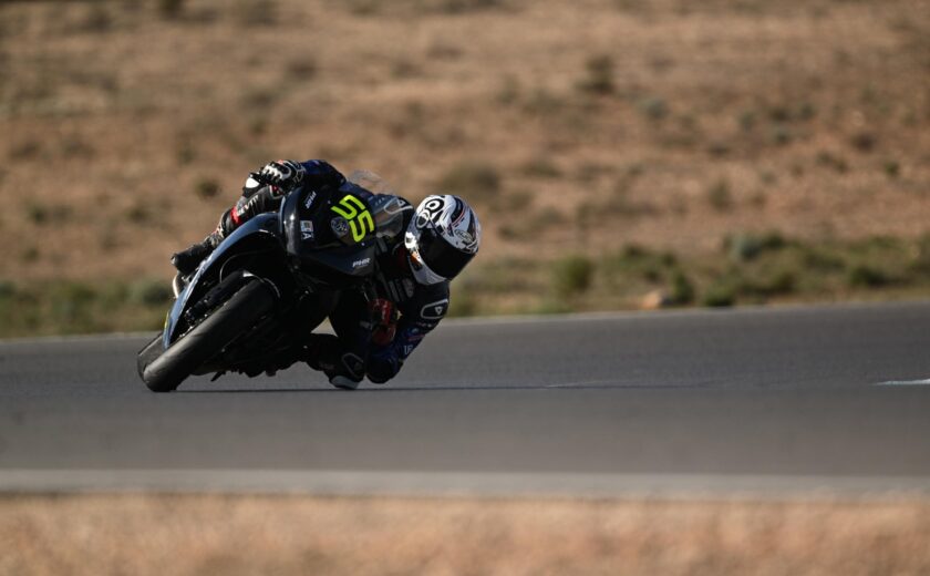 Motorcycle racer leaning into track bend