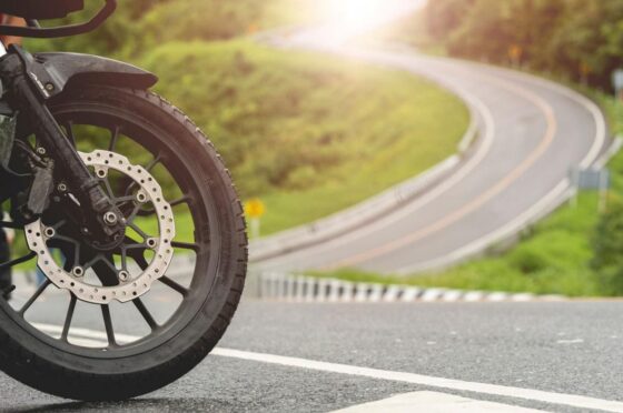 Motorcycle wheel on sunny road bend