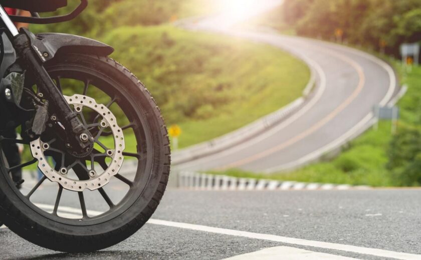Motorcycle wheel on sunny road bend