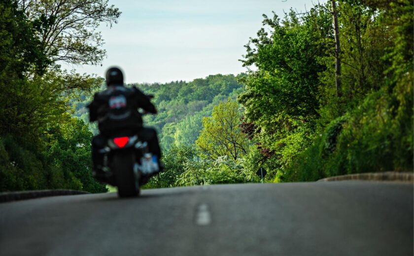 Motorcyclist riding along country road