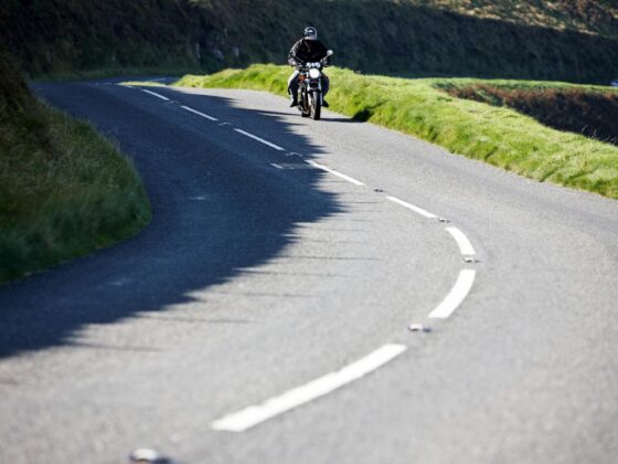 Motorcyclist riding along winding road