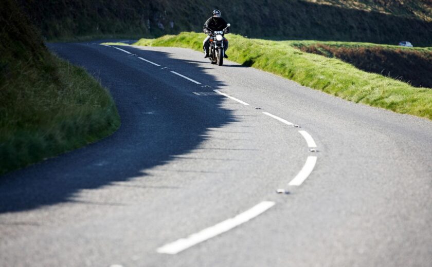 Motorcyclist riding along winding road