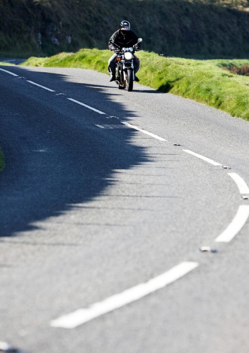 Motorcyclist riding along winding road