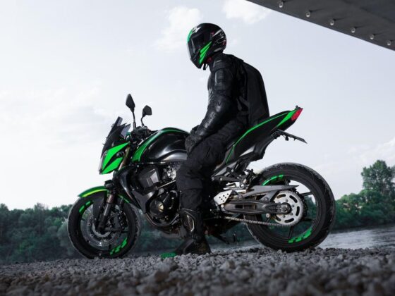 Motorcyclist seated on green motorcycle