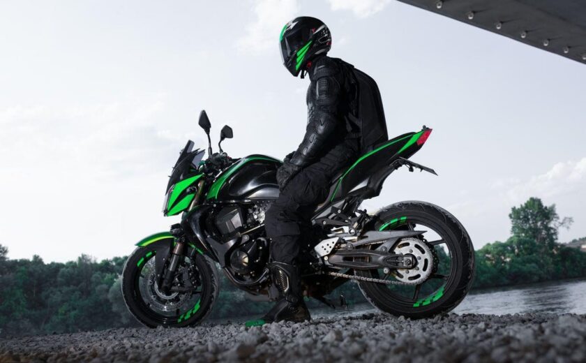 Motorcyclist seated on green motorcycle