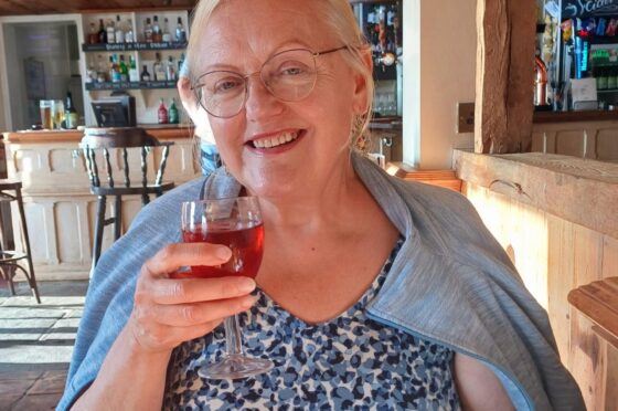 Mrs Brodrick smiling at outdoor table