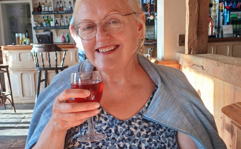 Mrs Brodrick smiling at outdoor table