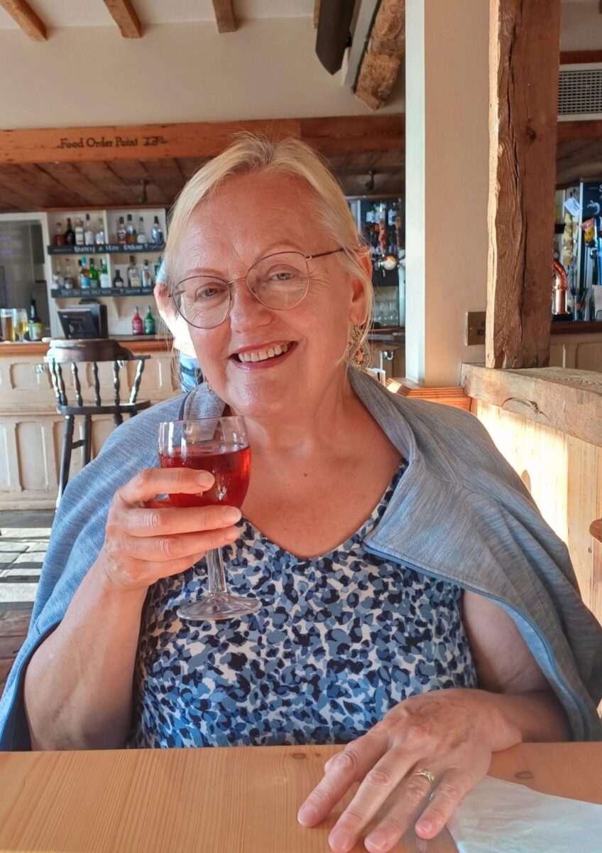 Mrs Brodrick smiling at outdoor table