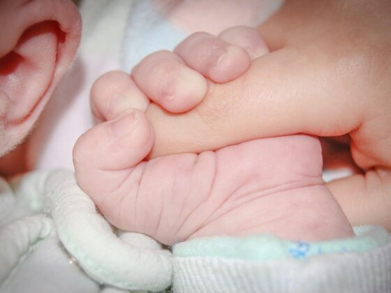 Newborn holding adult finger