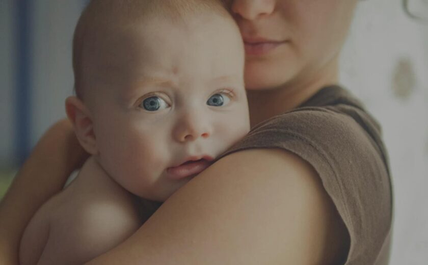 Parent holding baby against shoulder
