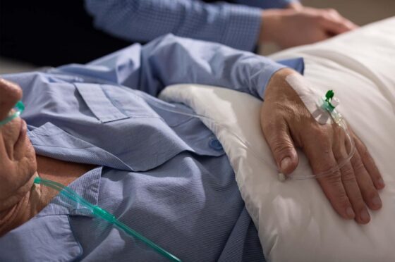 Patient lying in hospital bed with IV