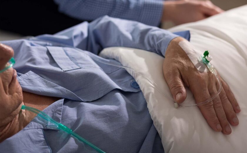Patient lying in hospital bed with IV