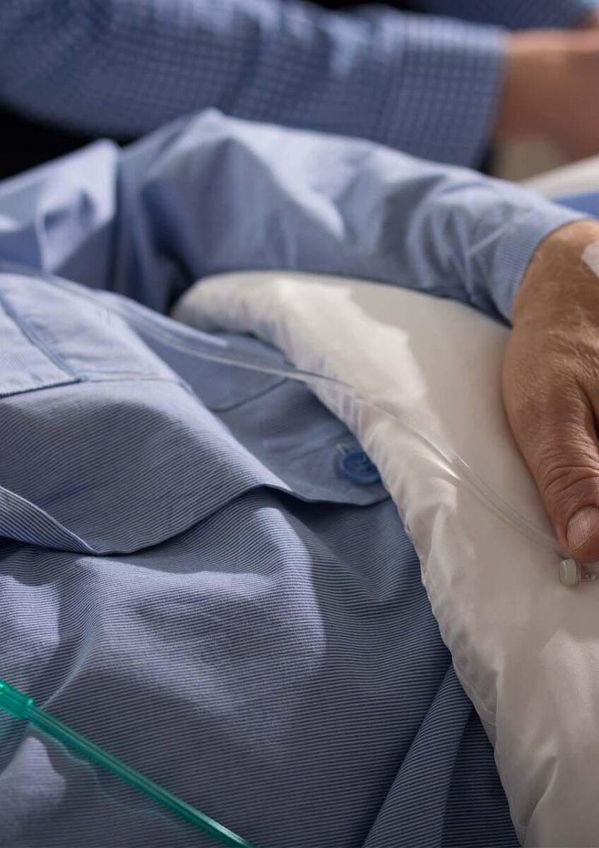 Patient lying in hospital bed with IV