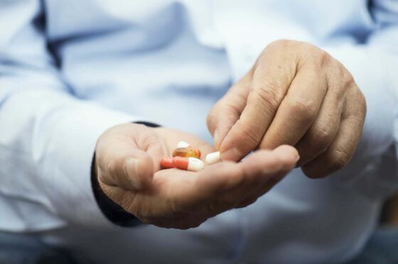Patient taking tablets from doctor's hand