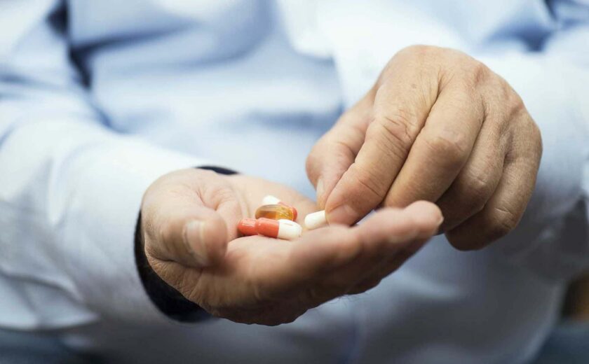 Patient taking tablets from doctor's hand