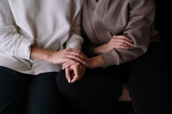 People holding hands on sofa