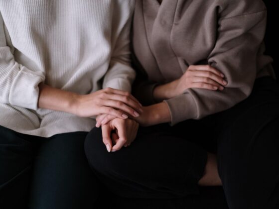 People holding hands on sofa