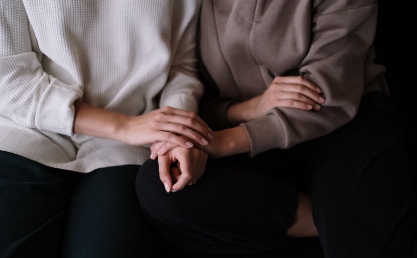 People holding hands on sofa