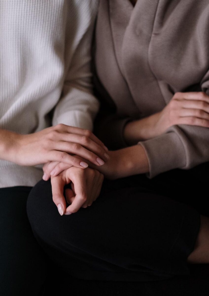People holding hands on sofa