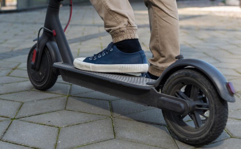 Person riding electric scooter on pavement