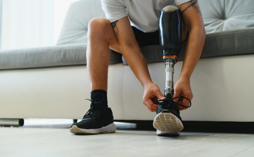 Person with prosthetic leg tying shoelace