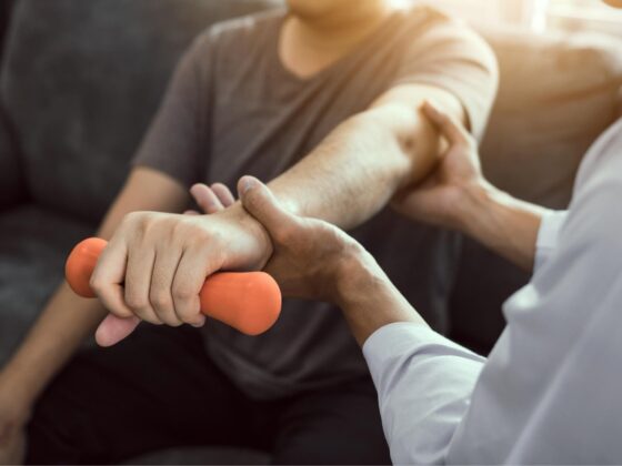 Physiotherapist supporting hand therapy exercise