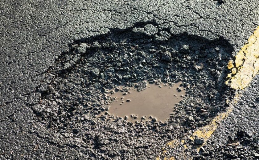 Pothole in damaged road surface