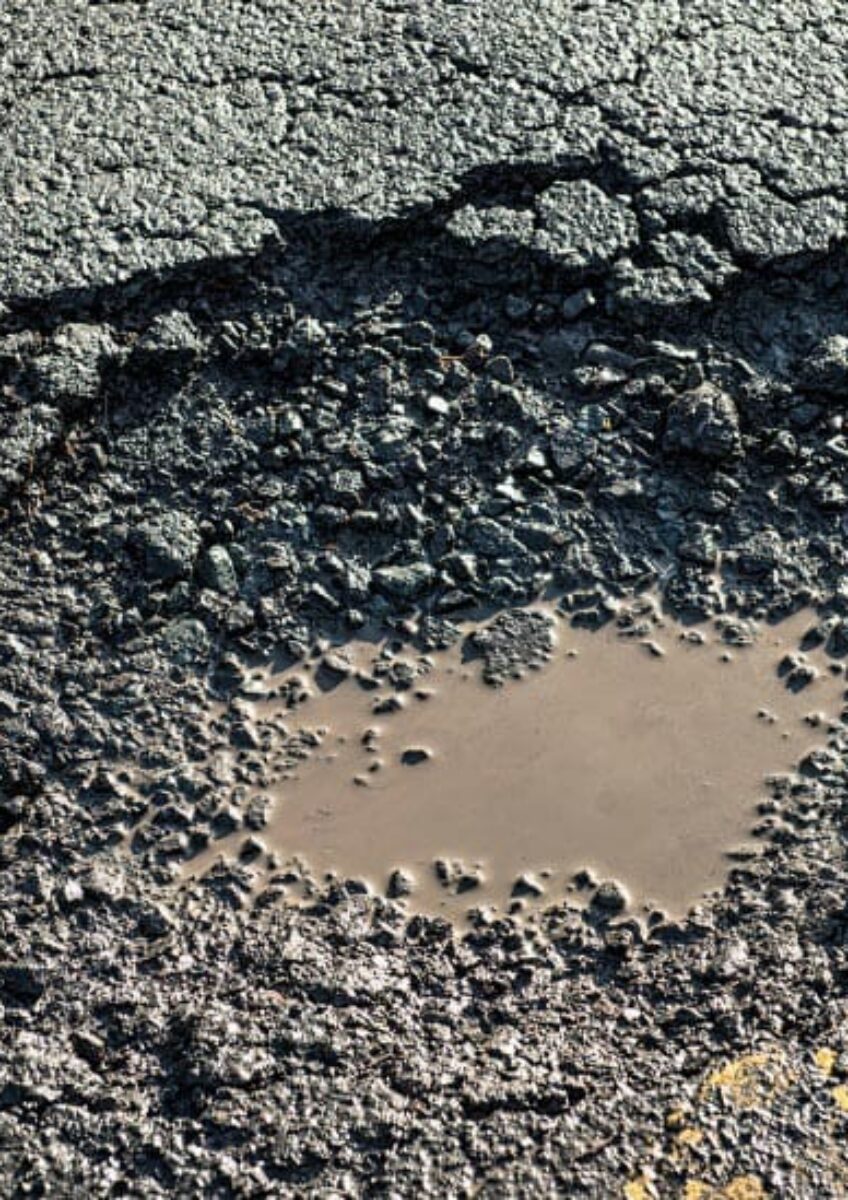 Pothole in damaged road surface