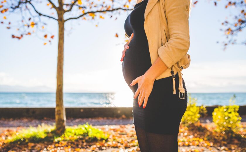 Pregnant woman standing in autumn park