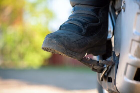 Rider's boot resting on motorcycle footpeg