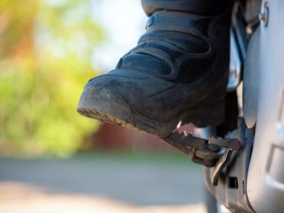 Rider's boot resting on motorcycle footpeg