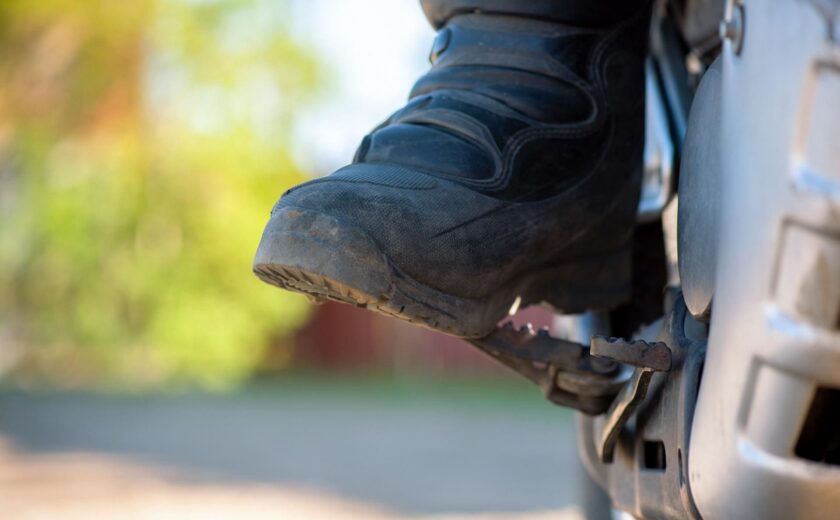 Rider's boot resting on motorcycle footpeg