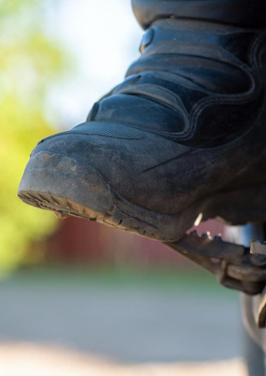 Rider's boot resting on motorcycle footpeg