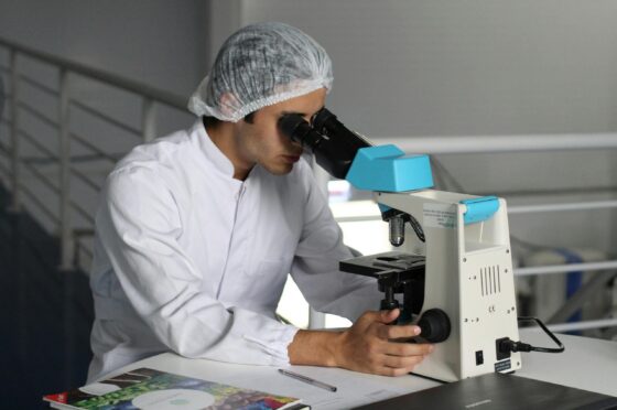 Scientist examining sample under microscope