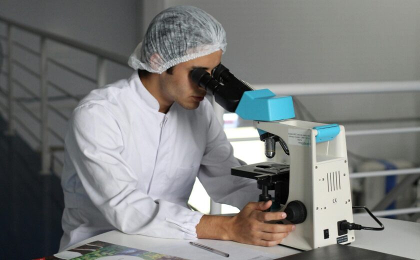 Scientist examining sample under microscope