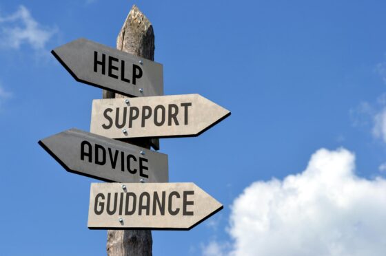 Wooden signpost with arrows labeled Help, Support, Advice, Guidance