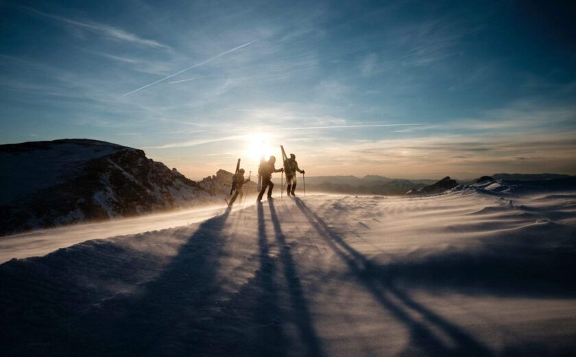 Skiers crossing snowy mountain ridge